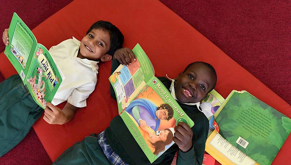 Children in Uganda show off their books. Boosting literacy is a priority for the government as it seeks to reduce poverty.